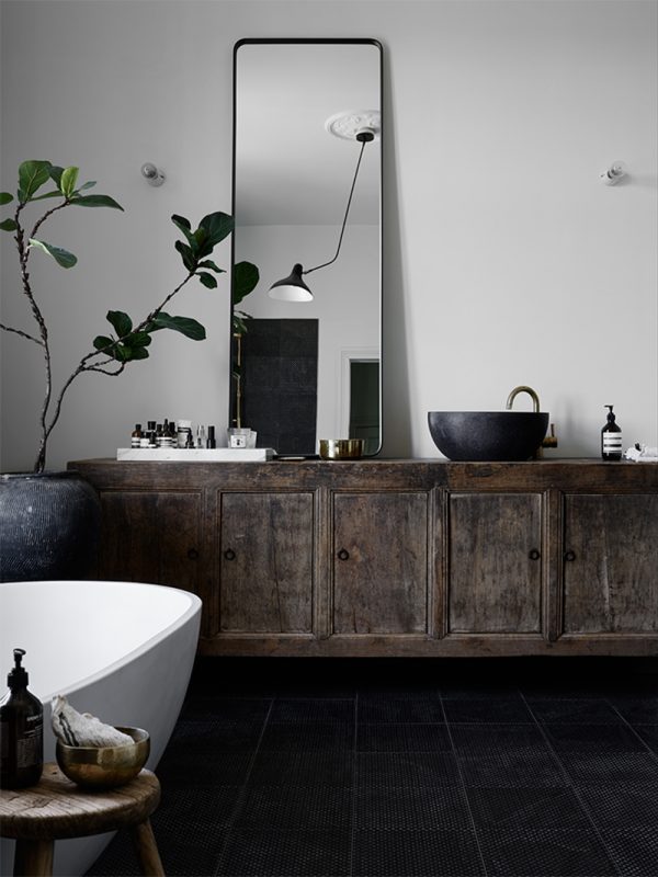 bathroom-with-black-textured-floor-tiles-old-vintage-cabinet-big-green-plant